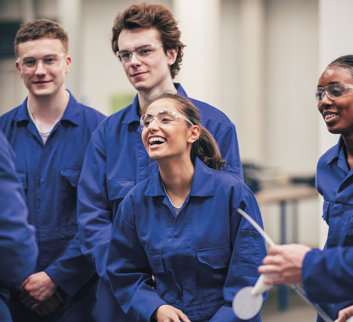 group of young employees in boiler suits laughing and smiling