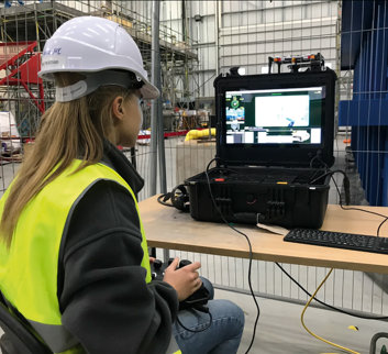 young female apprentice sat using a piece of equipment