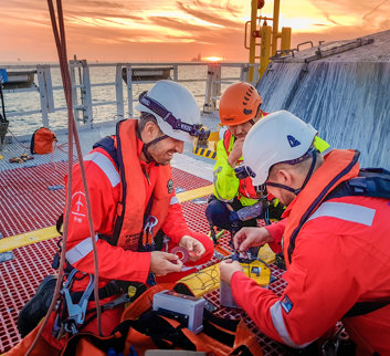 Men in life jackets and hard hats working on offshore asset