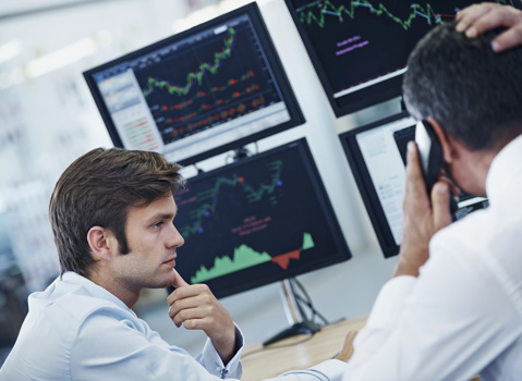 Two men with monitors with analytics in the background